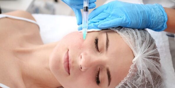 Kosmetolog wykonuje zabieg odmładzania skóry twarzy za pomocą plazmy
